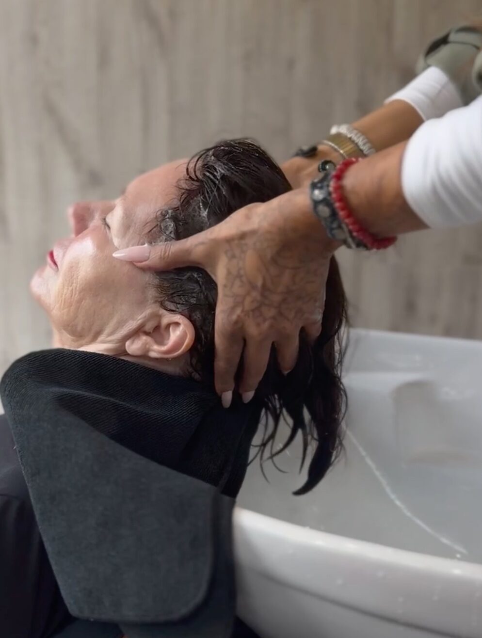A Garnish guest indulges in luxury hair care at a stylist's shampoo bowl
